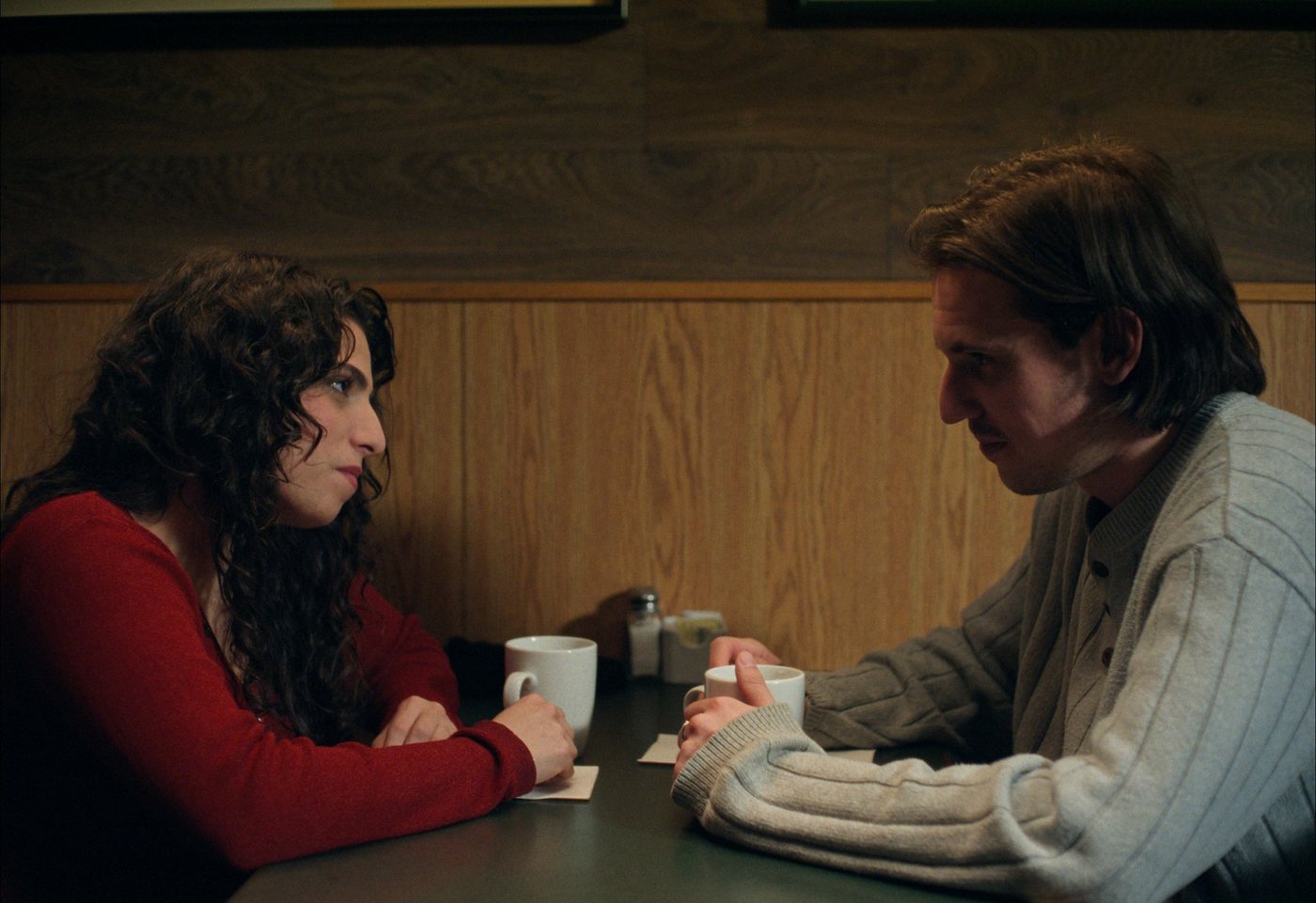 Yasmin and Joseph facing each other across a diner table.